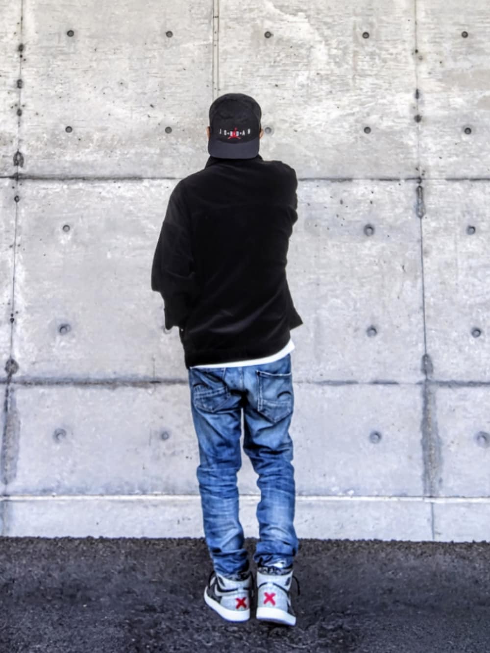 ブラック系のジャケット/アウター、ホワイト系のTシャツ/カットソー、ブルー系のデニムパンツを着用したメンズの秋コーディネートの2枚目の写真