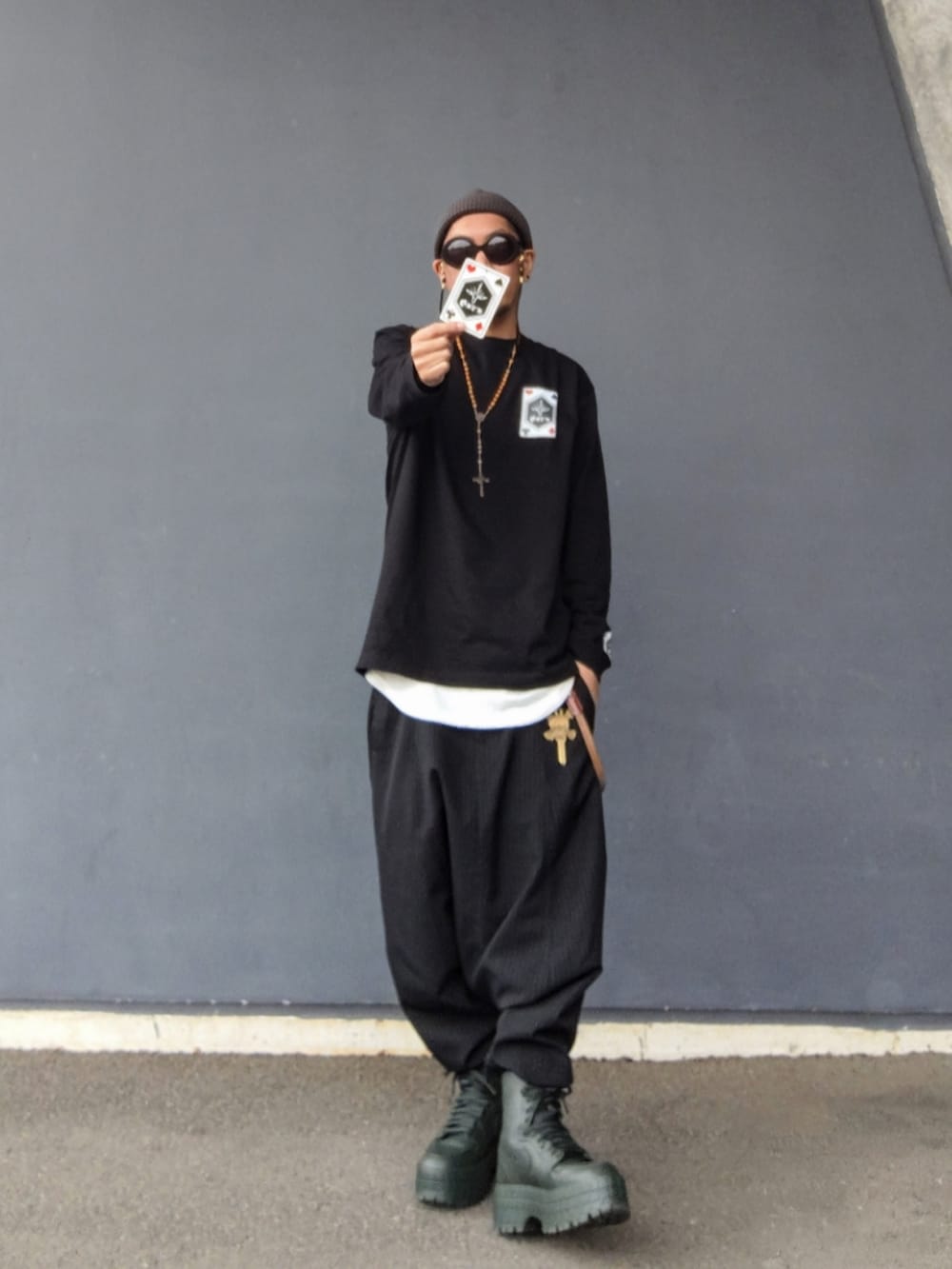 ブラック系のTシャツ/カットソー、ブラック系のその他パンツ、グリーン系のブーツを着用したメンズの春コーディネートの2枚目の写真