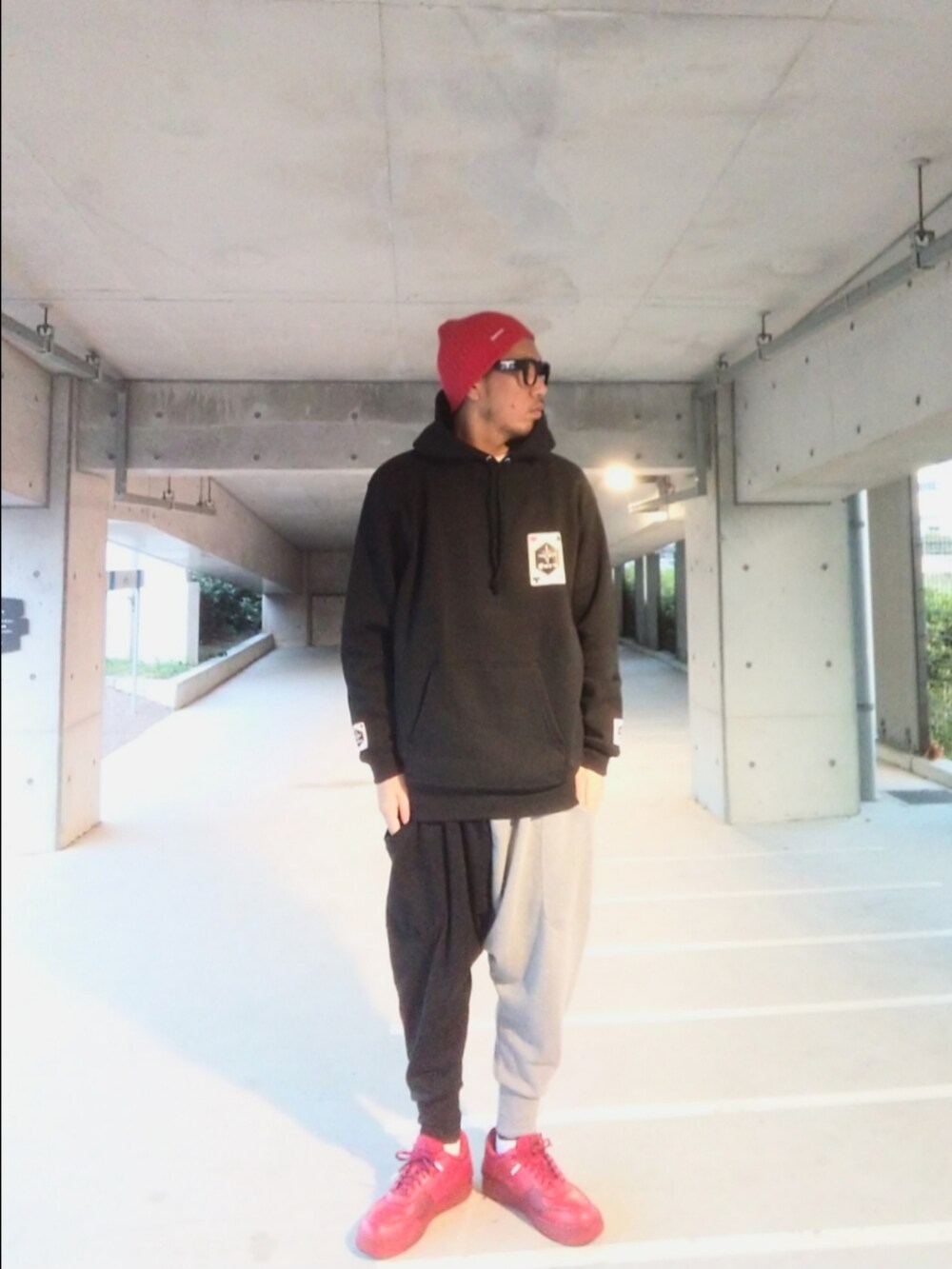 ブラック系のパーカー、レッド系のスニーカー、その他のスウェットパンツを着用したメンズの秋コーディネートの5枚目の写真
