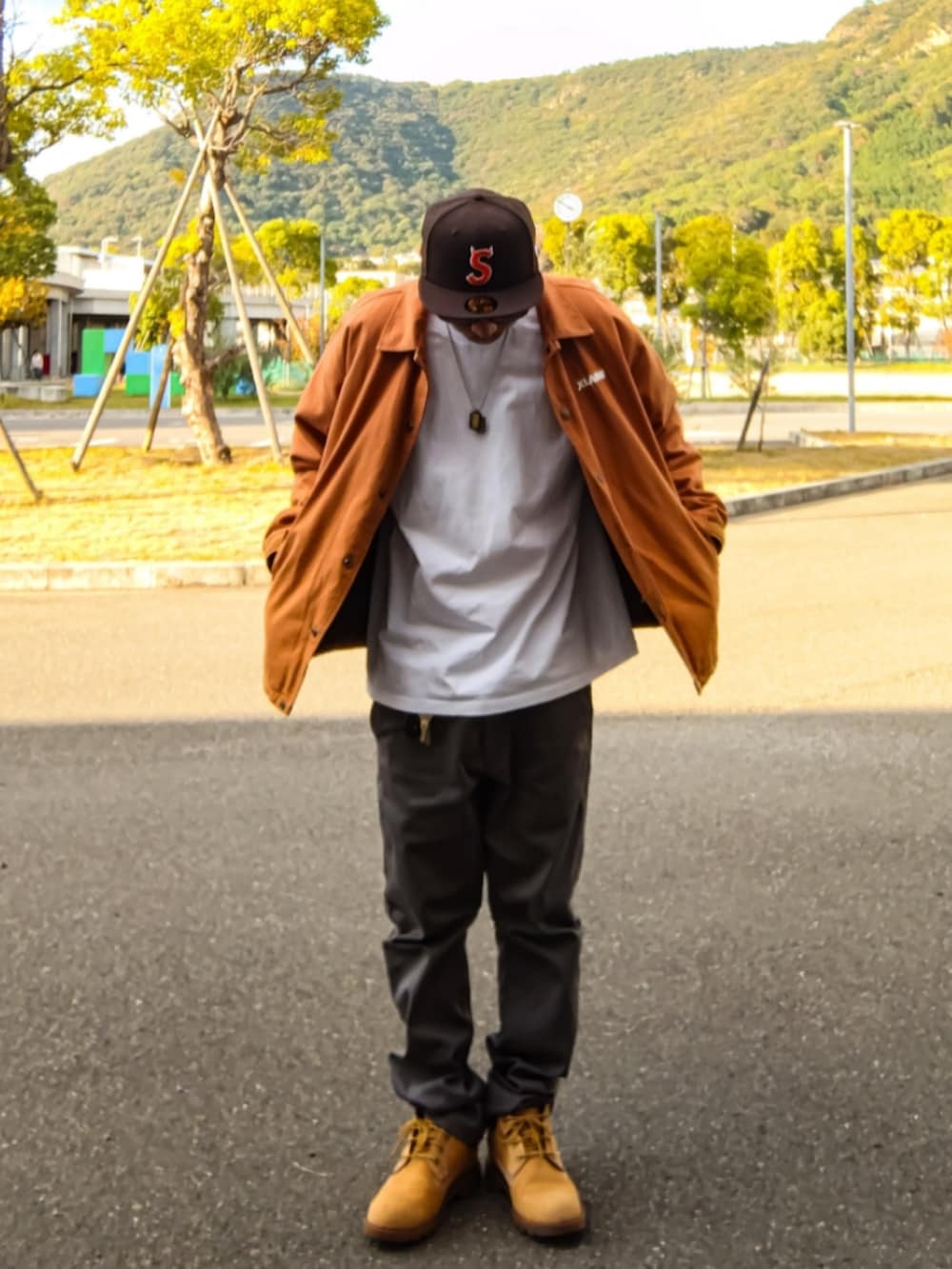 ブラウン系のブルゾン、ホワイト系のTシャツ/カットソー、グレー系のチノパンツを着用したメンズの秋コーディネートの2枚目の写真