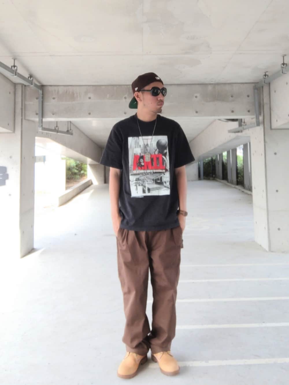 ブラック系のTシャツ/カットソー、ブラウン系のその他パンツ、イエロー系のブーツを着用したメンズの夏コーディネートの2枚目の写真