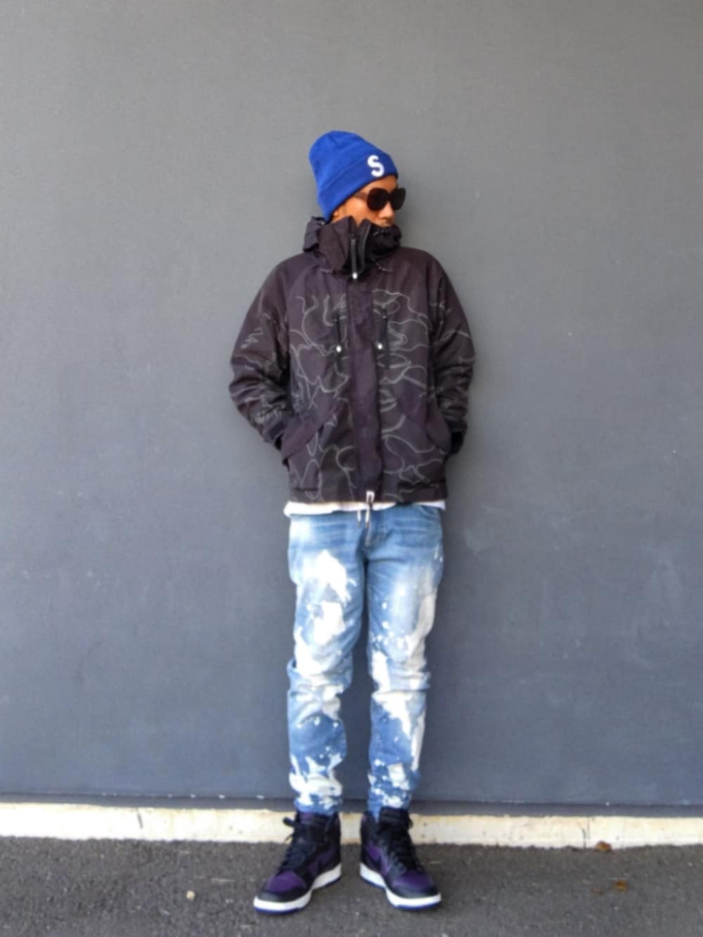 ブラック系のミリタリージャケット、ブルー系のデニムパンツ、パープル系のスニーカーを着用したメンズの冬コーディネートの2枚目の写真