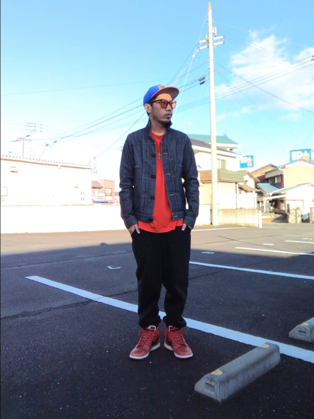 ブルー系のデニムジャケット、オレンジ系のTシャツ/カットソー、ブラック系のスウェットパンツを着用したメンズの冬コーディネートの2枚目の写真