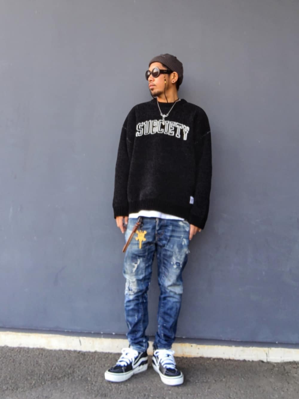 ブラック系のニット/セーター、ホワイト系のTシャツ/カットソー、ブラック系のスニーカーを着用したメンズの冬コーディネートの2枚目の写真