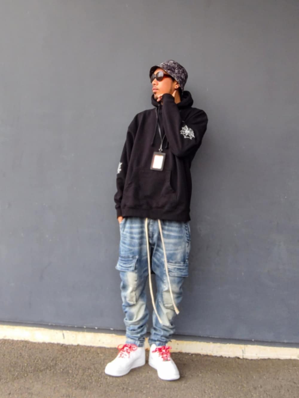 ブラック系のパーカー、ブルー系のデニムパンツ、ホワイト系のスニーカーを着用したメンズの冬コーディネートの2枚目の写真