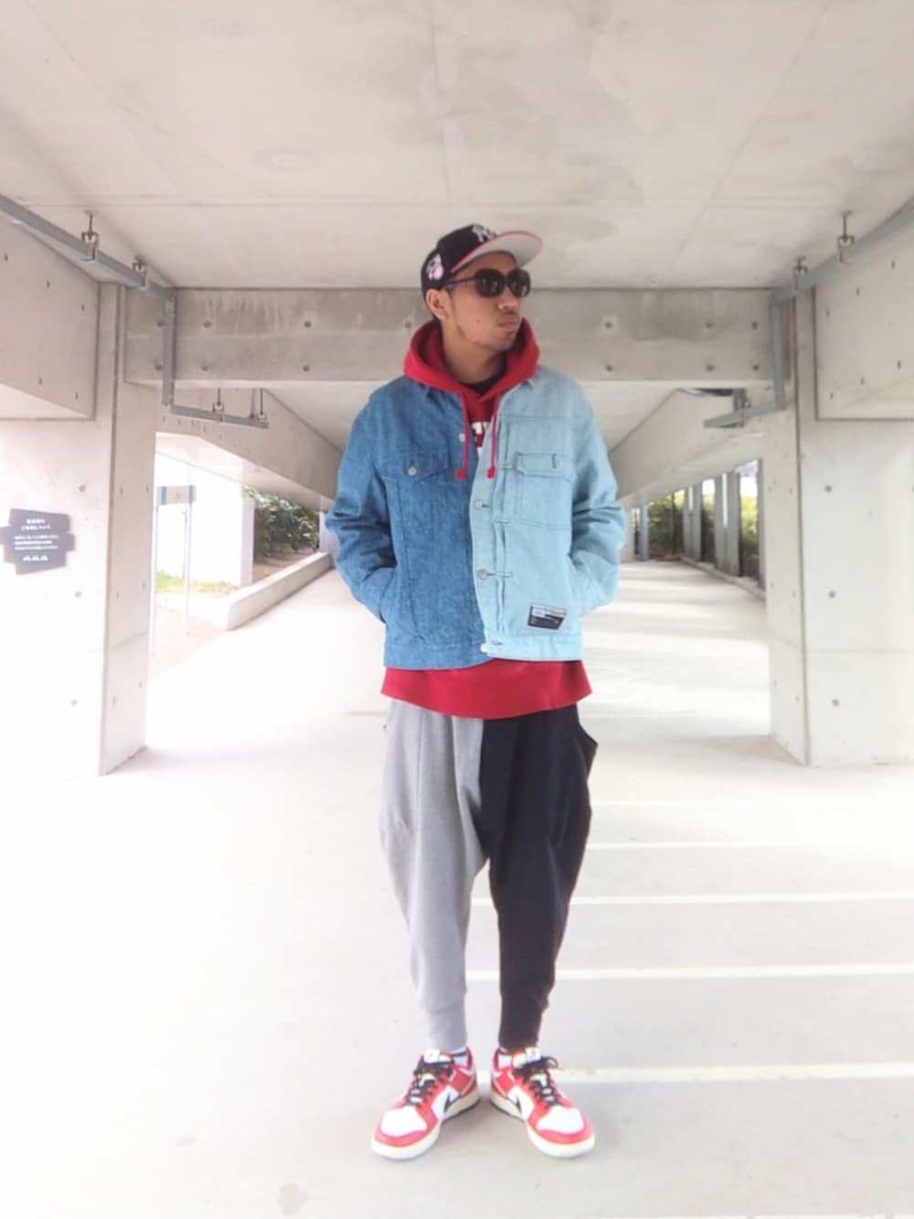 ブルー系のデニムジャケット、レッド系のパーカー、その他のスウェットパンツを着用したメンズの冬コーディネートの3枚目の写真