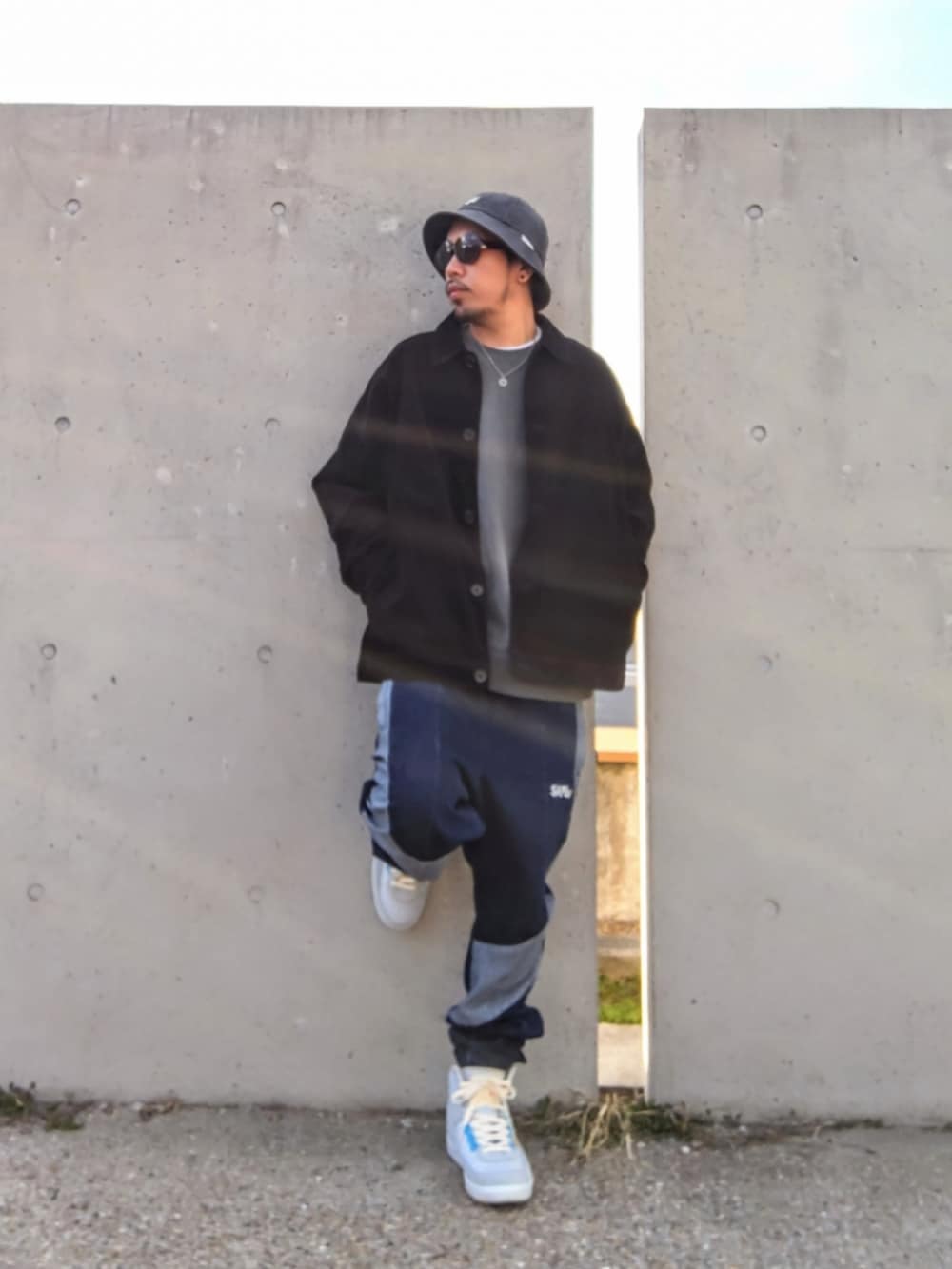 ブラック系のジャケット/アウター、グレー系のスウェット、ブルー系のデニムパンツを着用したメンズの冬コーディネートの2枚目の写真