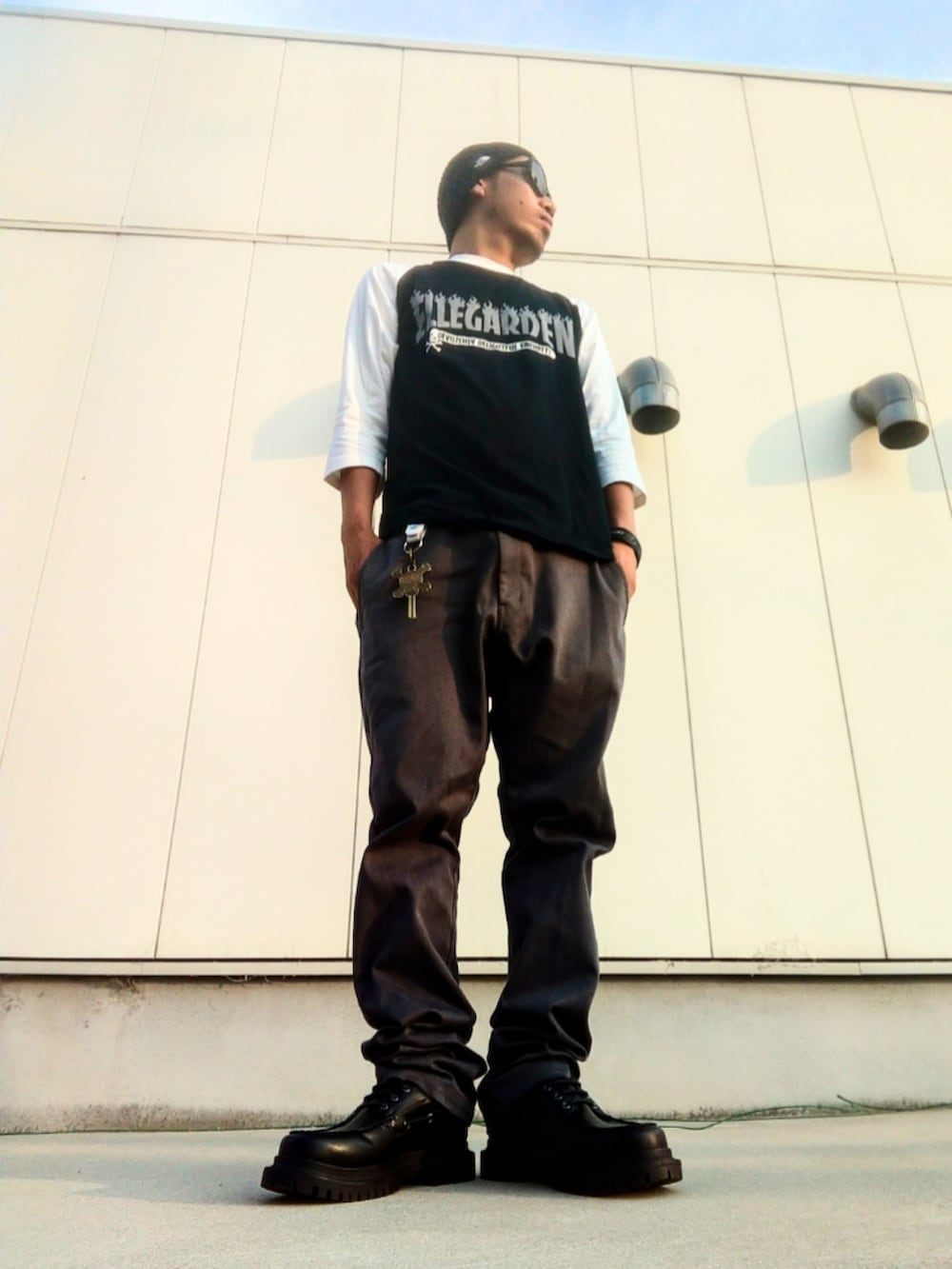 ブラック系のTシャツ/カットソー、グレー系のチノパンツ、ブラック系のモカシン/デッキシューズを着用したメンズの夏コーディネートの2枚目の写真