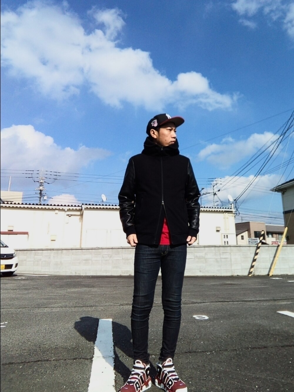 ブラック系のスタジャン、レッド系のTシャツ/カットソー、ブルー系のデニムパンツを着用したメンズの冬コーディネートの2枚目の写真