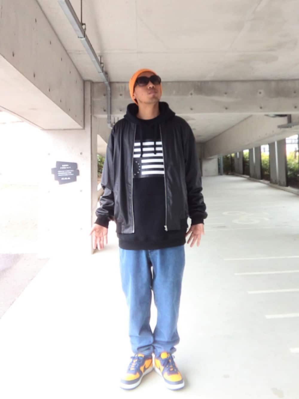 ブラック系のジャケット/アウター、ブラック系のパーカー、ブルー系のデニムパンツを着用したメンズの春コーディネートの2枚目の写真