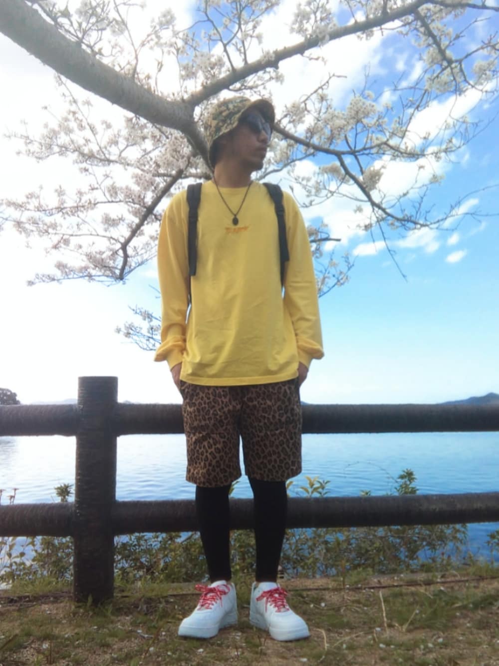 イエロー系のTシャツ/カットソー、ブラック系のバックパック/リュック、その他のその他パンツを着用したメンズの春コーディネートの3枚目の写真