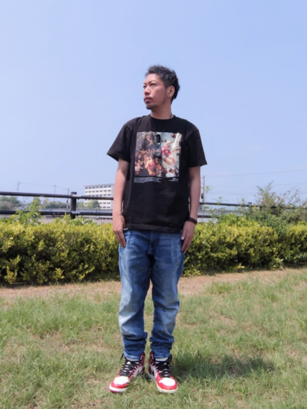 ブラック系のTシャツ/カットソー、ブルー系のデニムパンツ、レッド系のスニーカーを着用したメンズの夏コーディネートの4枚目の写真