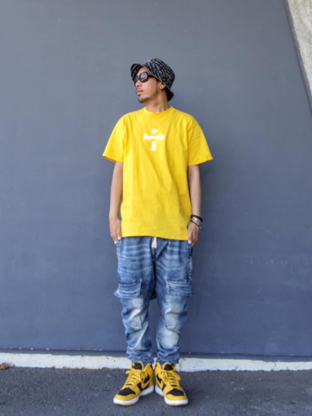イエロー系のTシャツ/カットソー、ブルー系のデニムパンツ、イエロー系のスニーカーを着用したメンズの春コーディネートの2枚目の写真
