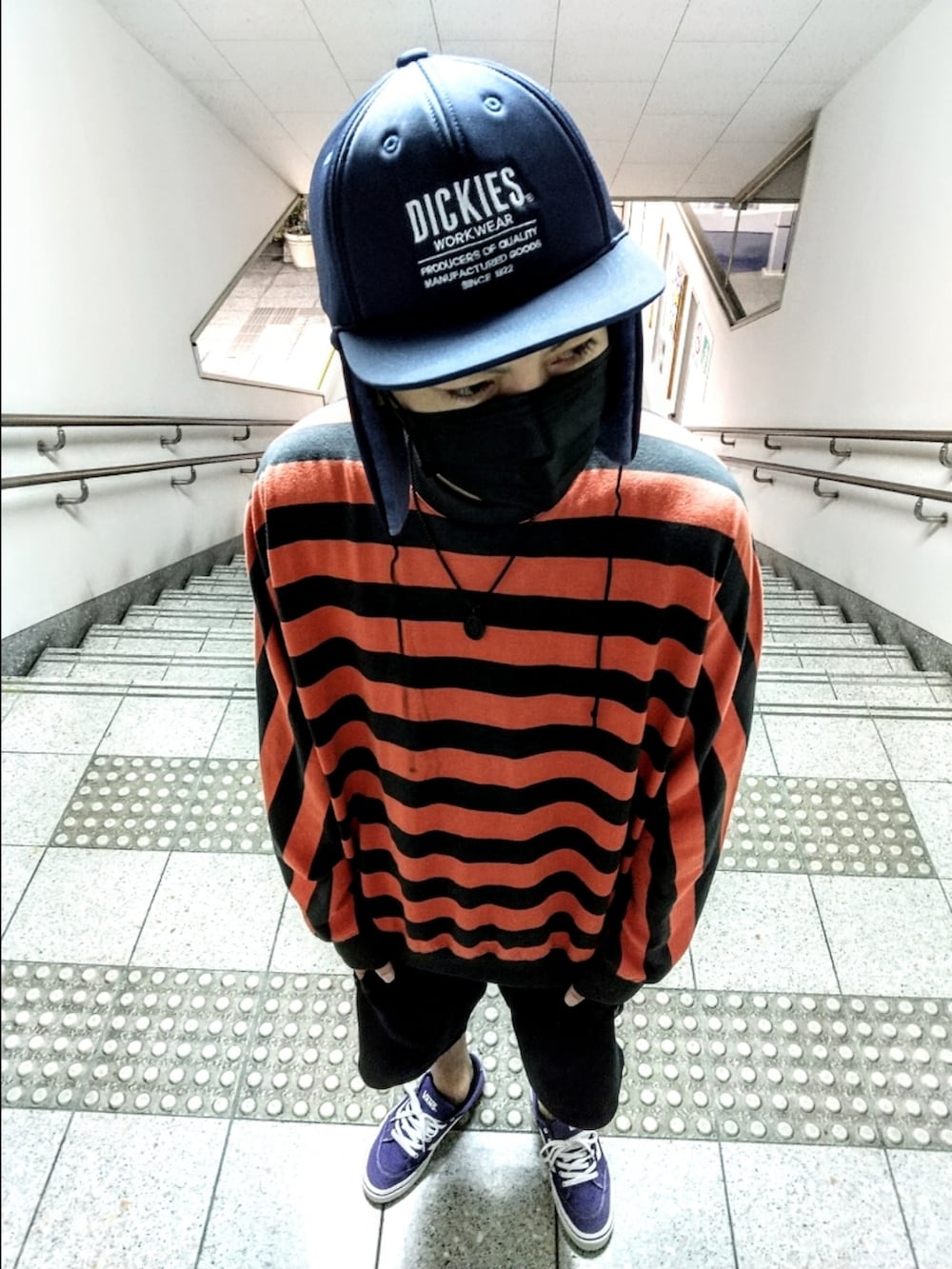 オレンジ系のニット/セーター、ブラック系のその他パンツ、パープル系のスニーカーを着用したメンズの秋コーディネートの3枚目の写真