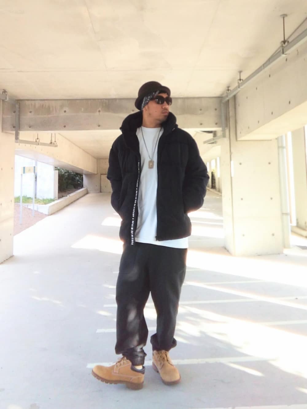 ブラック系のダウンジャケット/コート、ブラック系のスウェットパンツ、イエロー系のブーツを着用したメンズの冬コーディネートの2枚目の写真