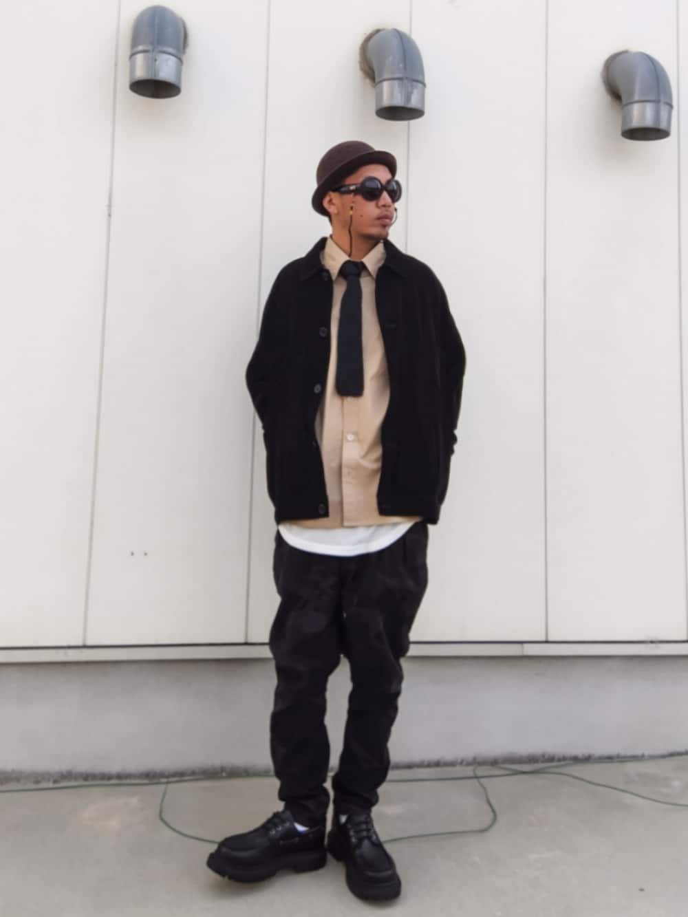 ブラック系のジャケット/アウター、ベージュ系のシャツ/ブラウス、ホワイト系のタンクトップを着用したメンズの秋コーディネートの2枚目の写真