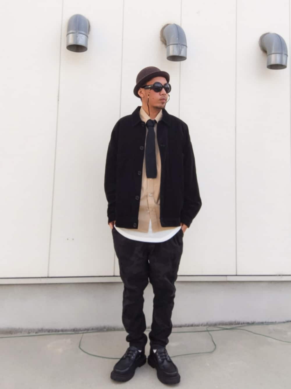 ブラック系のジャケット/アウター、ベージュ系のシャツ/ブラウス、ホワイト系のタンクトップを着用したメンズの秋コーディネートの3枚目の写真