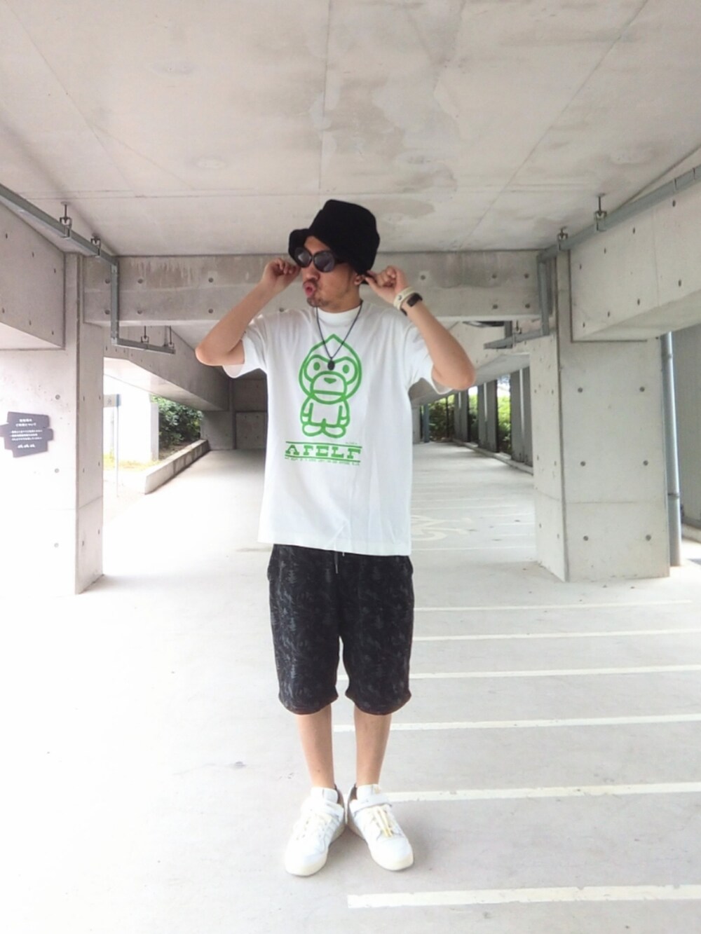 ホワイト系のTシャツ/カットソー、ブラック系のパンツ、ホワイト系のスニーカーを着用したメンズの夏コーディネートの2枚目の写真