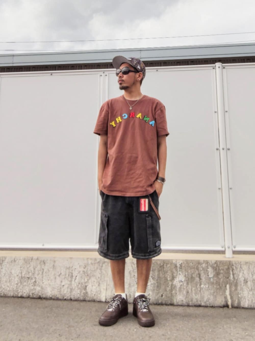 ブラウン系のTシャツ/カットソー、ブラック系のその他パンツ、ブラウン系のスニーカーを着用したメンズの夏コーディネートの2枚目の写真