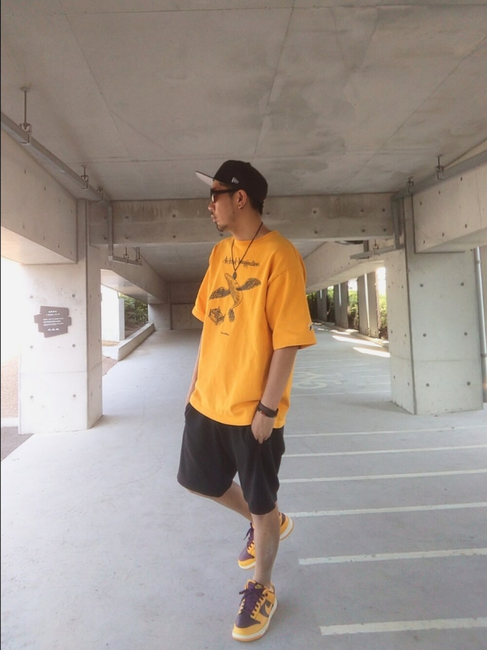 イエロー系のTシャツ/カットソー、ブラック系のその他パンツ、イエロー系のスニーカーを着用したメンズの秋コーディネートの2枚目の写真