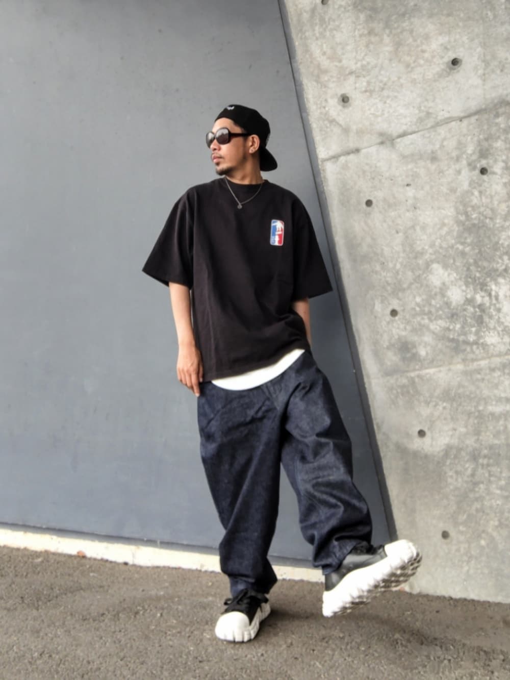 ブラック系のTシャツ/カットソー、ホワイト系のタンクトップ、ブルー系のデニムパンツを着用したメンズの春コーディネートの2枚目の写真