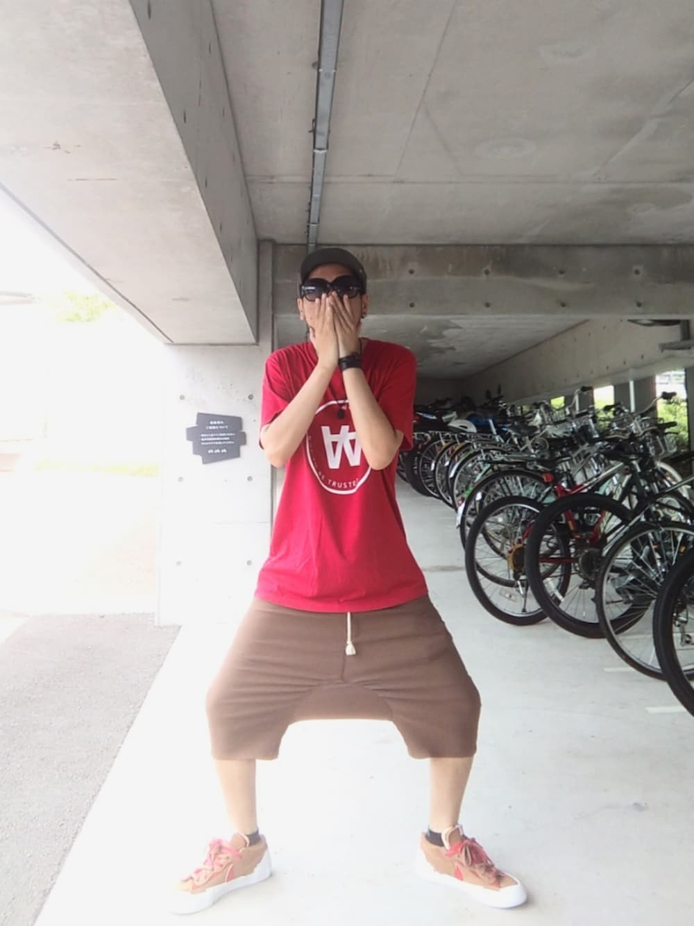 レッド系のTシャツ/カットソー、ブラウン系のその他パンツ、ブラウン系のスニーカーを着用したメンズの夏コーディネートの2枚目の写真