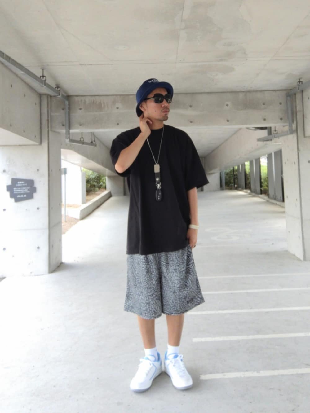 ブラック系のTシャツ/カットソー、グレー系のパンツ、ホワイト系のスニーカーを着用したメンズの夏コーディネートの2枚目の写真