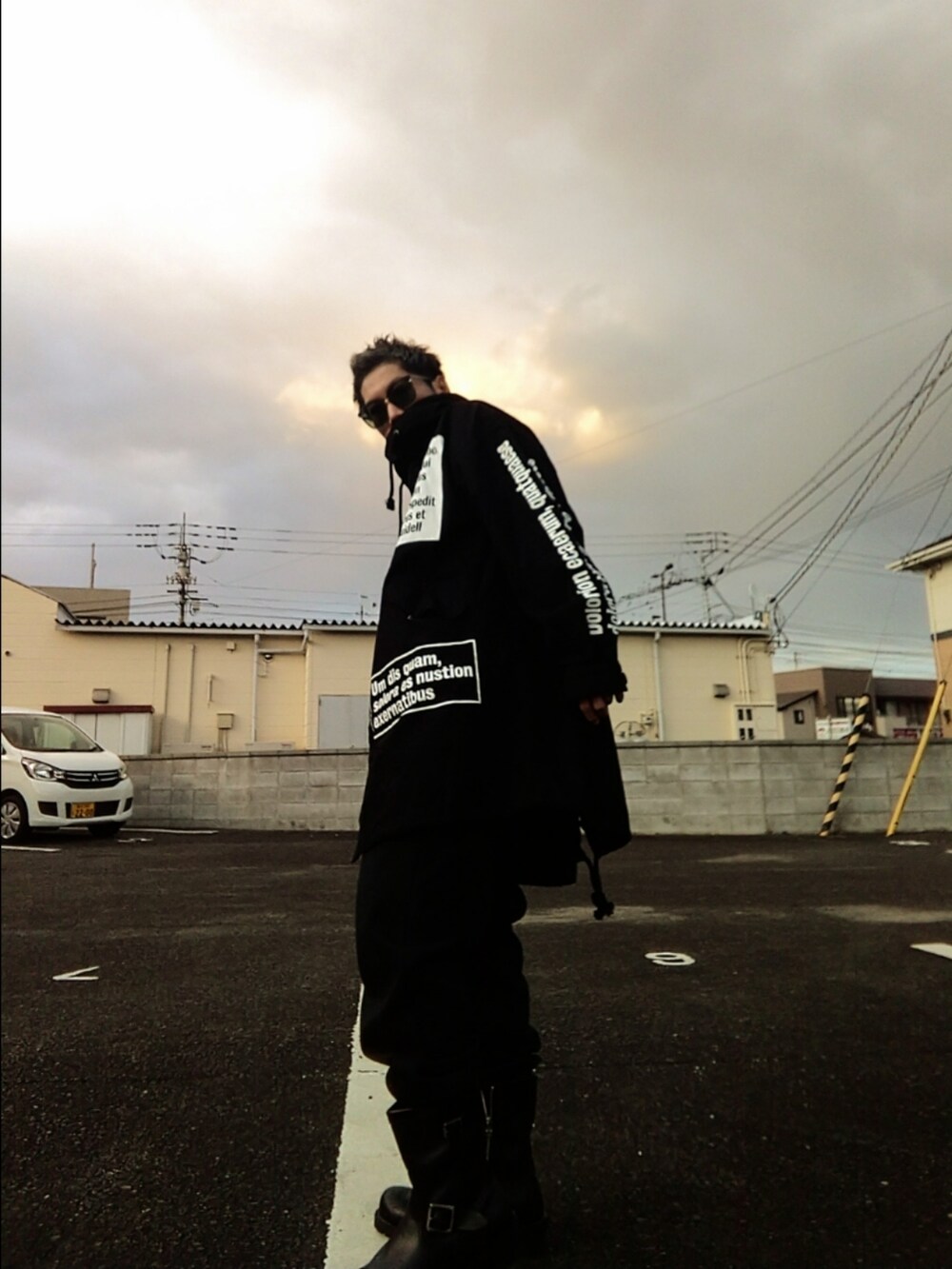 ブラック系のモッズコート、ブラック系のスウェットパンツ、ブラック系のブーツを着用したメンズの冬コーディネートの2枚目の写真