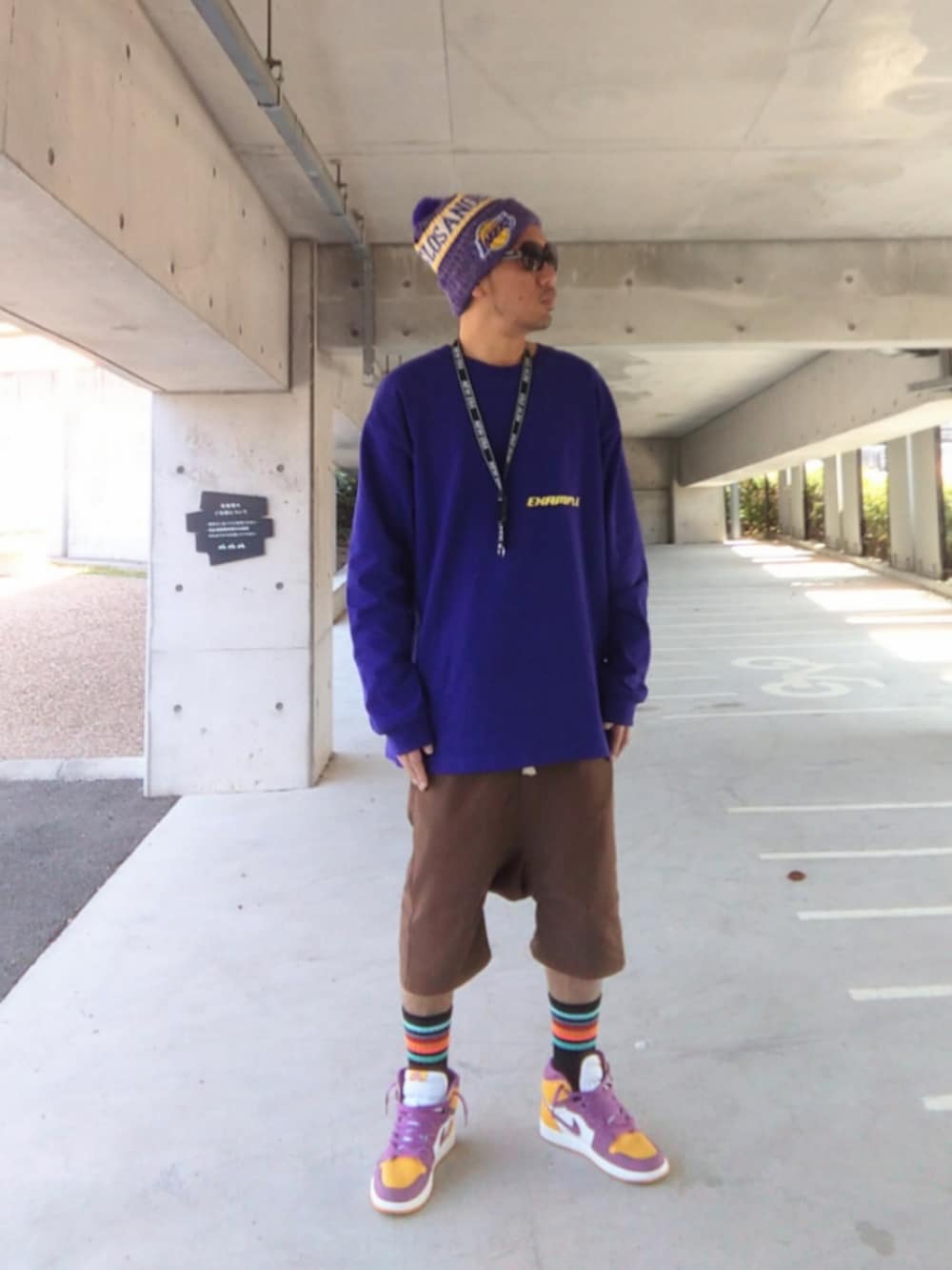 「example、NEW ERA、レイカーズ、ポンポン帽子、ニット帽、ロンT、ファミマ靴下、フジロック、Jordan、NIKE、ネックストラップ、サルエルショーツ、春めき満開コーデ、ストリート、靴下オタク」｜「NEW ERAのアイテム（ニットキャップ/ビーニー、パープル系）」を使った、hasshi(ハッシー)さん（メンズ・172cm）の春コーディネートの2枚目の写真
