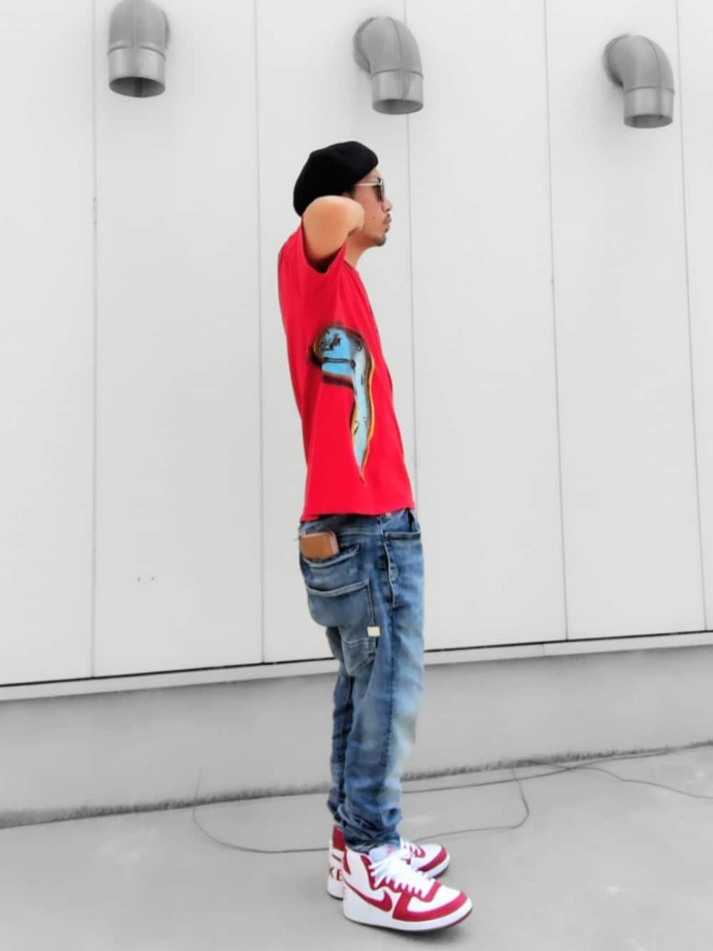 レッド系のTシャツ/カットソー、ブルー系のデニムパンツ、ホワイト系のスニーカーを着用したメンズの夏コーディネートの2枚目の写真