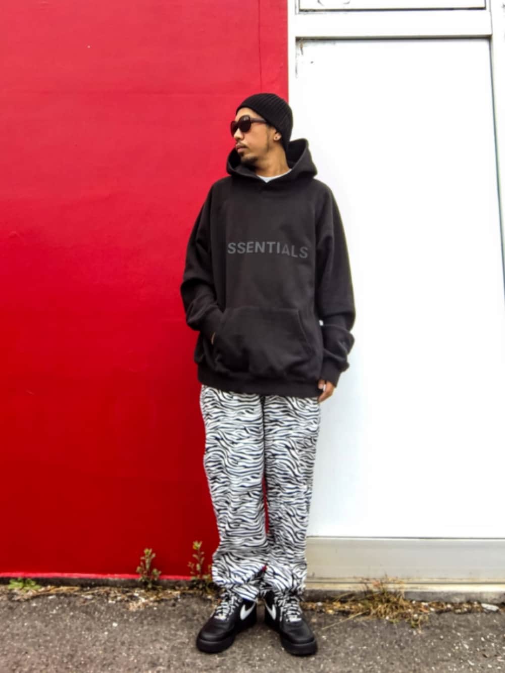 ブラック系のパーカー、ホワイト系のその他パンツ、ブラック系のスニーカーを着用したメンズの冬コーディネートの2枚目の写真