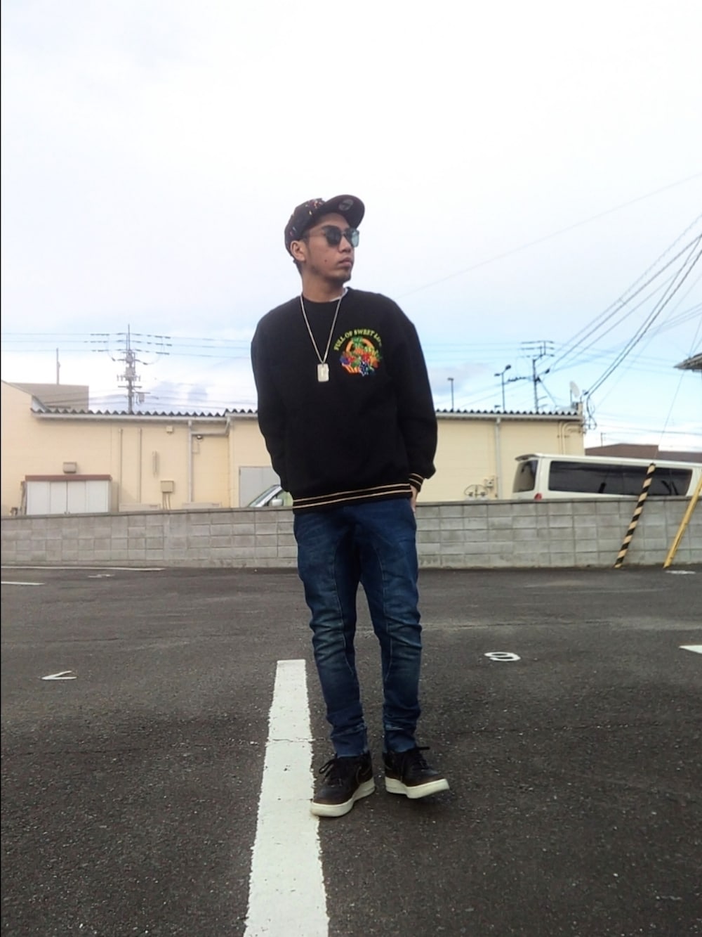 ブラック系のスウェット、ブラック系のスニーカー、ブルー系のパンツを着用したメンズの冬コーディネートの2枚目の写真