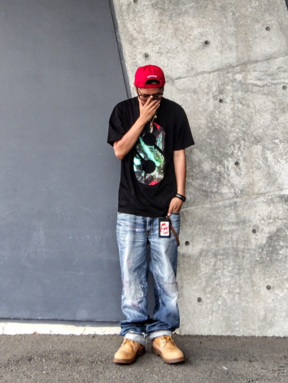 ブラック系のTシャツ/カットソー、ブルー系のデニムパンツ、イエロー系のブーツを着用したメンズの夏コーディネートの2枚目の写真