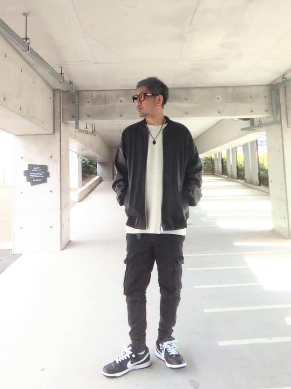 ブラック系のジャケット/アウター、ホワイト系のニット/セーター、ブラック系のデニムパンツを着用したメンズの冬コーディネートの2枚目の写真