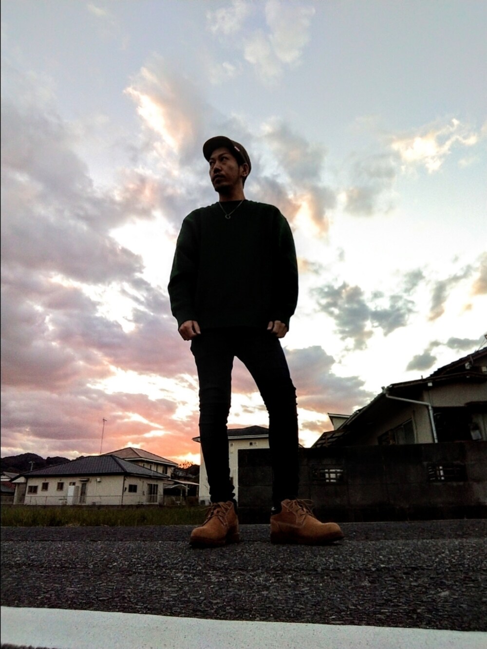 グリーン系のスウェット、ブルー系のデニムパンツ、イエロー系のブーツを着用したメンズの秋コーディネートの3枚目の写真