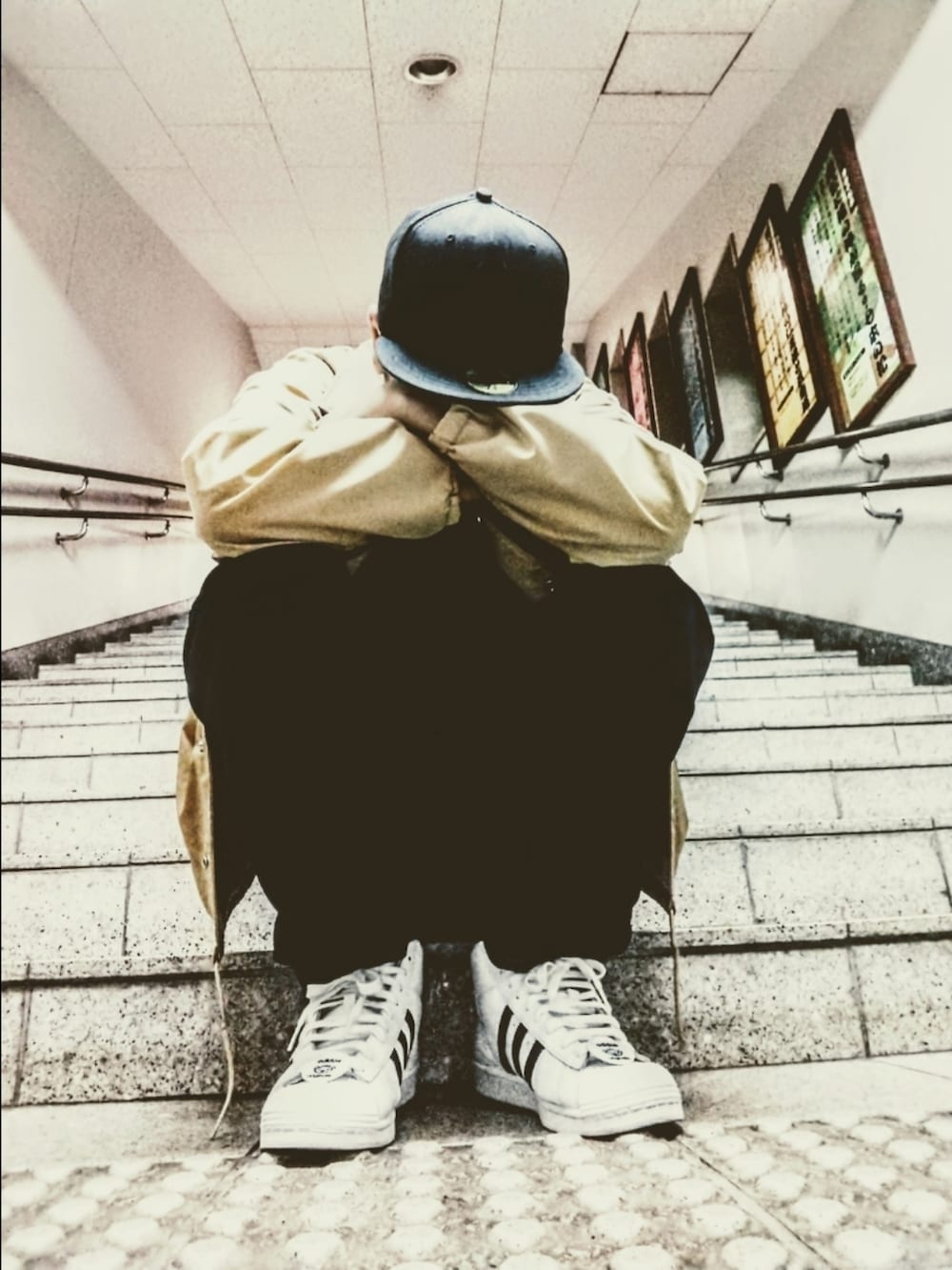 ベージュ系のナイロンジャケット、ブルー系のデニムパンツ、ホワイト系のスニーカーを着用したメンズの秋コーディネートの3枚目の写真