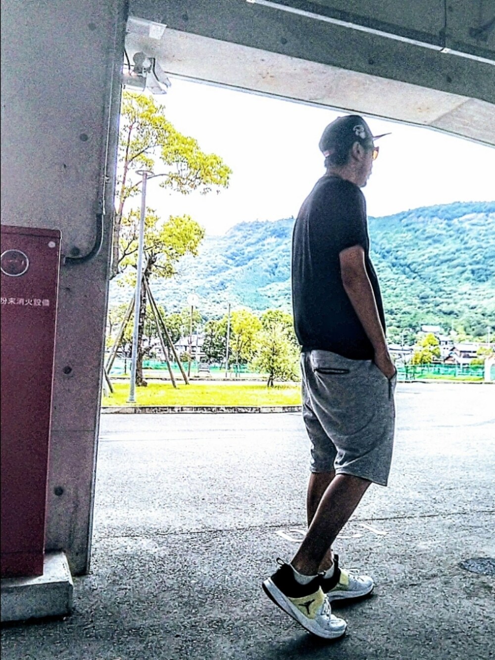 ブラック系のTシャツ/カットソー、グレー系のその他パンツ、ホワイト系のスニーカーを着用したメンズの夏コーディネートの3枚目の写真