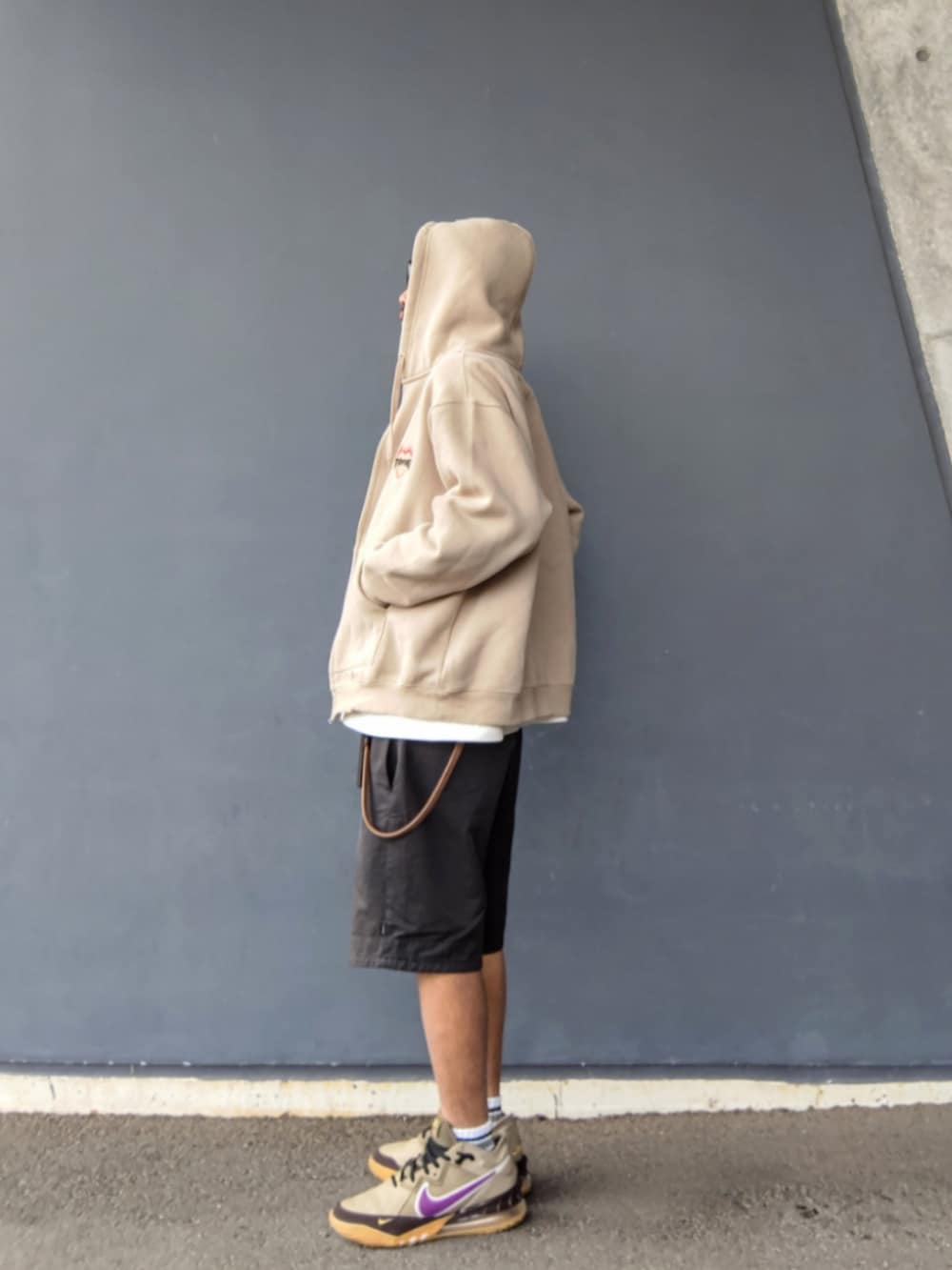 ベージュ系のパーカー、ブラック系のその他パンツ、ベージュ系のスニーカーを着用したメンズの春コーディネートの2枚目の写真