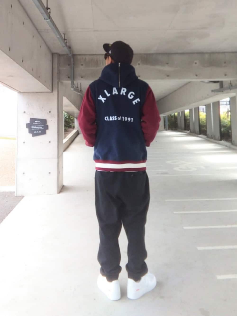 ブルー系のスタジャン、ホワイト系のTシャツ/カットソー、ブラック系のスウェットパンツを着用したメンズの春コーディネートの2枚目の写真