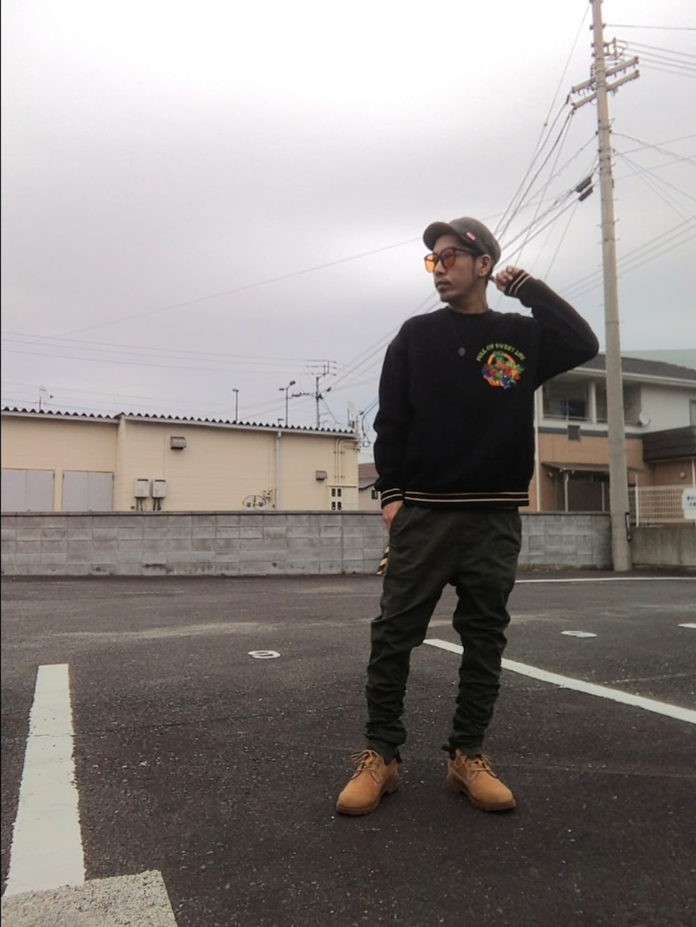 ブラック系のスウェット、グリーン系のパンツ、イエロー系のブーツを着用したメンズの秋コーディネートの3枚目の写真