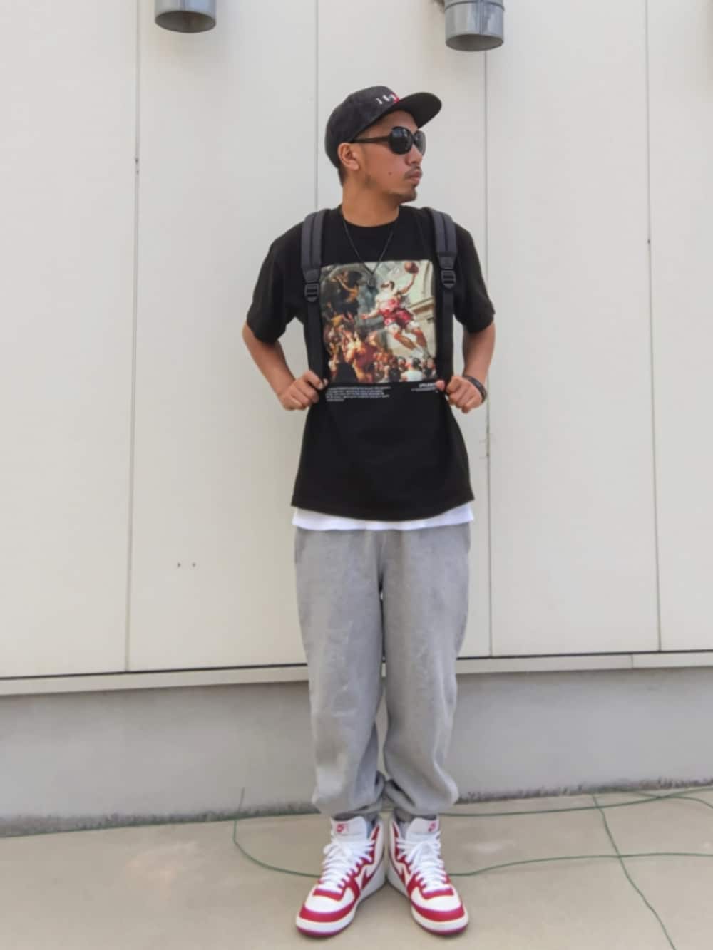 ブラック系のTシャツ/カットソー、ブラック系のバックパック/リュック、グレー系のスウェットパンツを着用したメンズの秋コーディネートの3枚目の写真