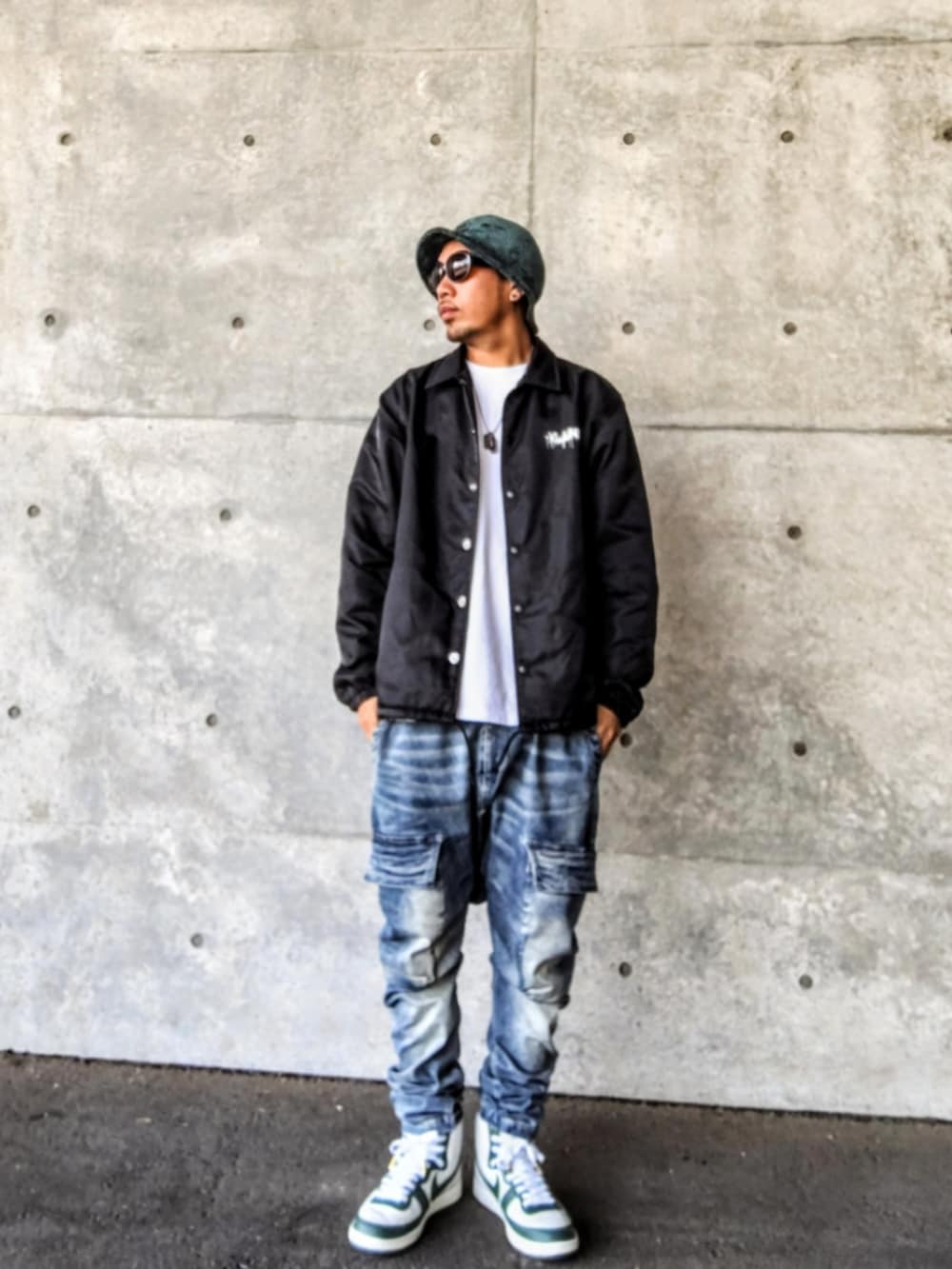 ブラック系のナイロンジャケット、ホワイト系のTシャツ/カットソー、ブルー系のデニムパンツを着用したメンズの秋コーディネートの2枚目の写真