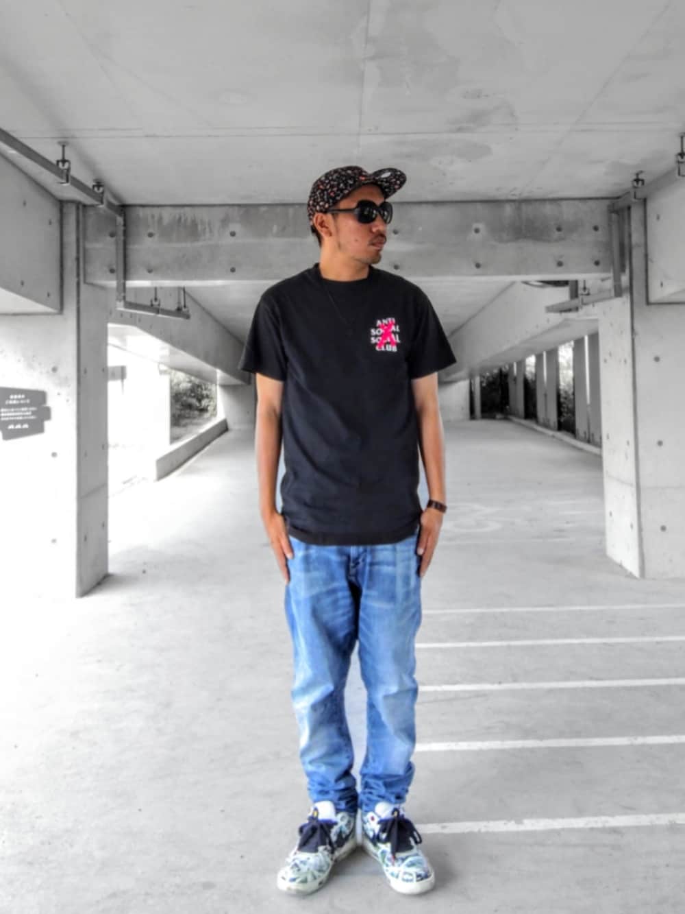 ブラック系のTシャツ/カットソー、ブルー系のデニムパンツ、ホワイト系のスニーカーを着用したメンズの夏コーディネートの2枚目の写真