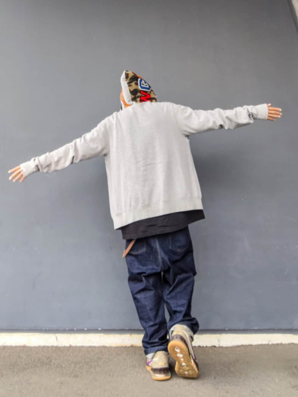 グレー系のパーカー、ブラック系のTシャツ/カットソー、ブルー系のデニムパンツを着用したメンズの春コーディネートの2枚目の写真