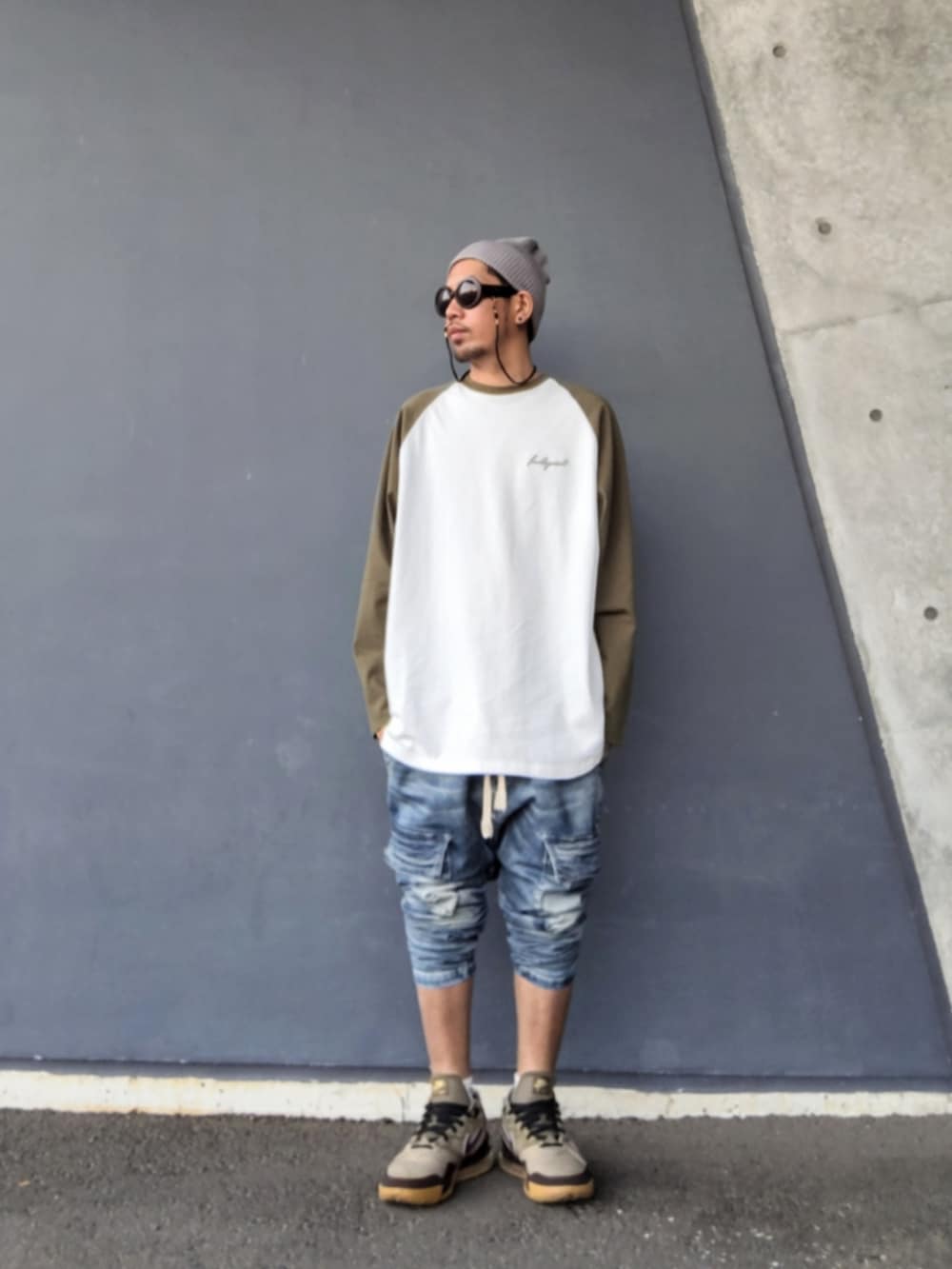 ホワイト系のTシャツ/カットソー、ブルー系のデニムパンツ、ベージュ系のスニーカーを着用したメンズの春コーディネートの2枚目の写真