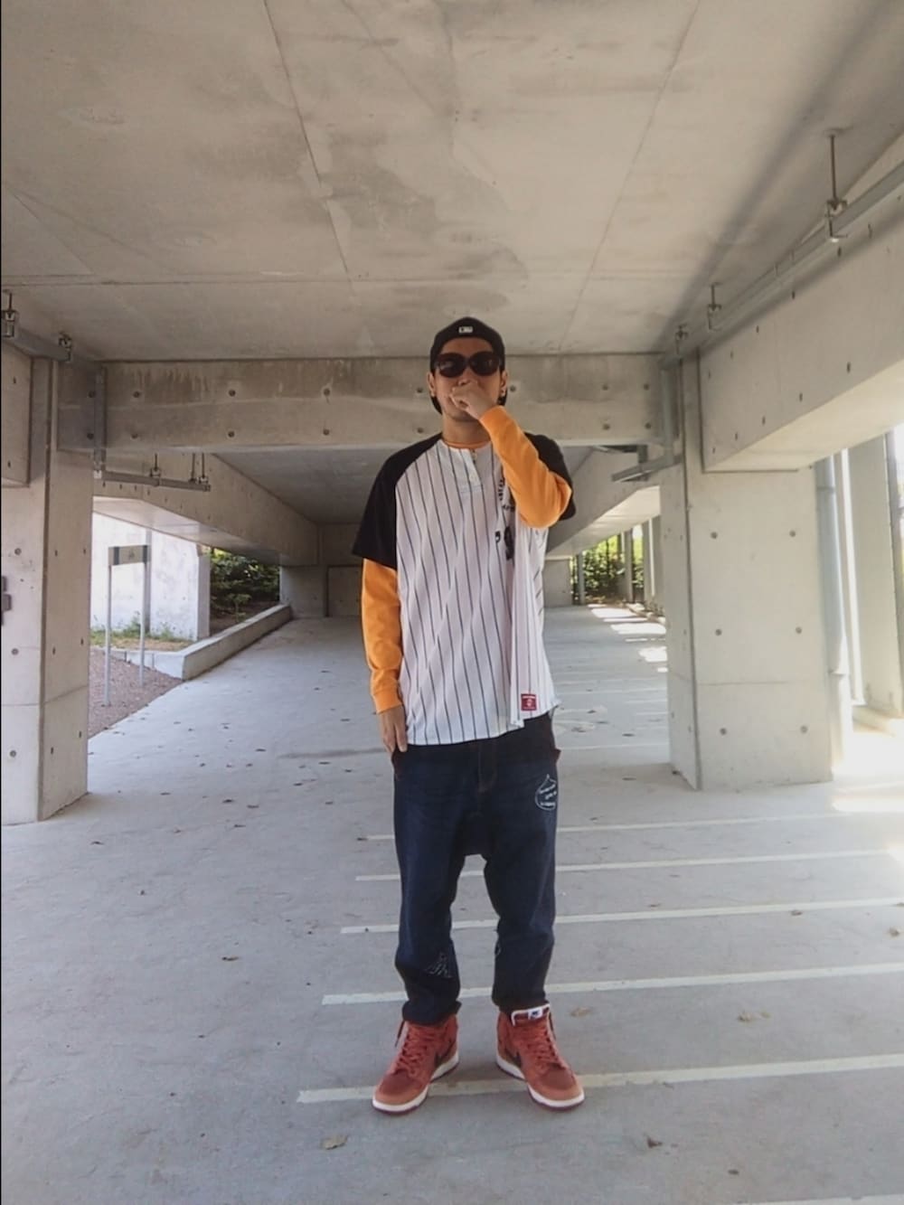 ホワイト系のシャツ/ブラウス、オレンジ系のTシャツ/カットソー、ブルー系のデニムパンツを着用したメンズの春コーディネートの2枚目の写真