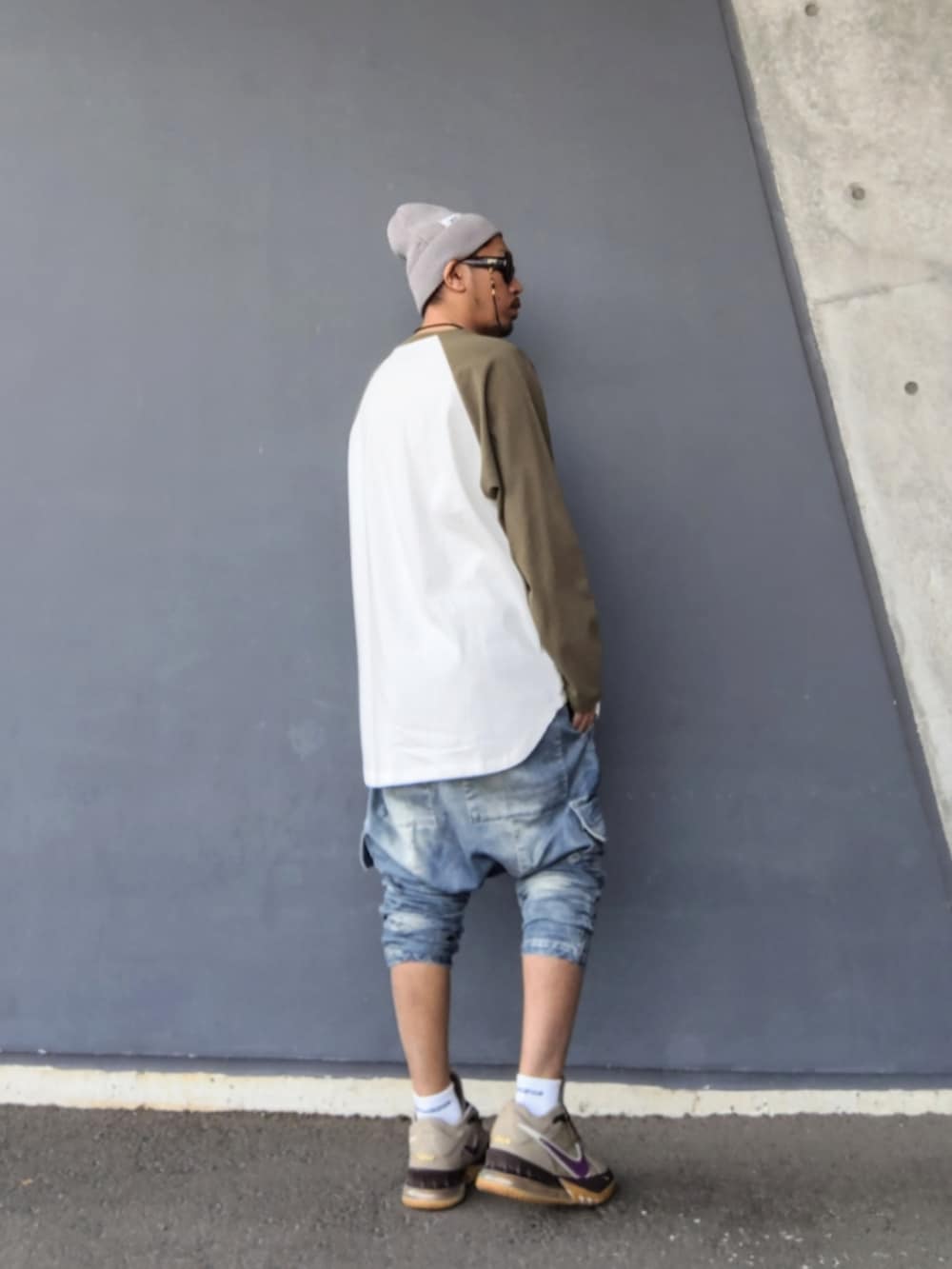 ホワイト系のTシャツ/カットソー、ブルー系のデニムパンツ、ベージュ系のスニーカーを着用したメンズの春コーディネートの3枚目の写真