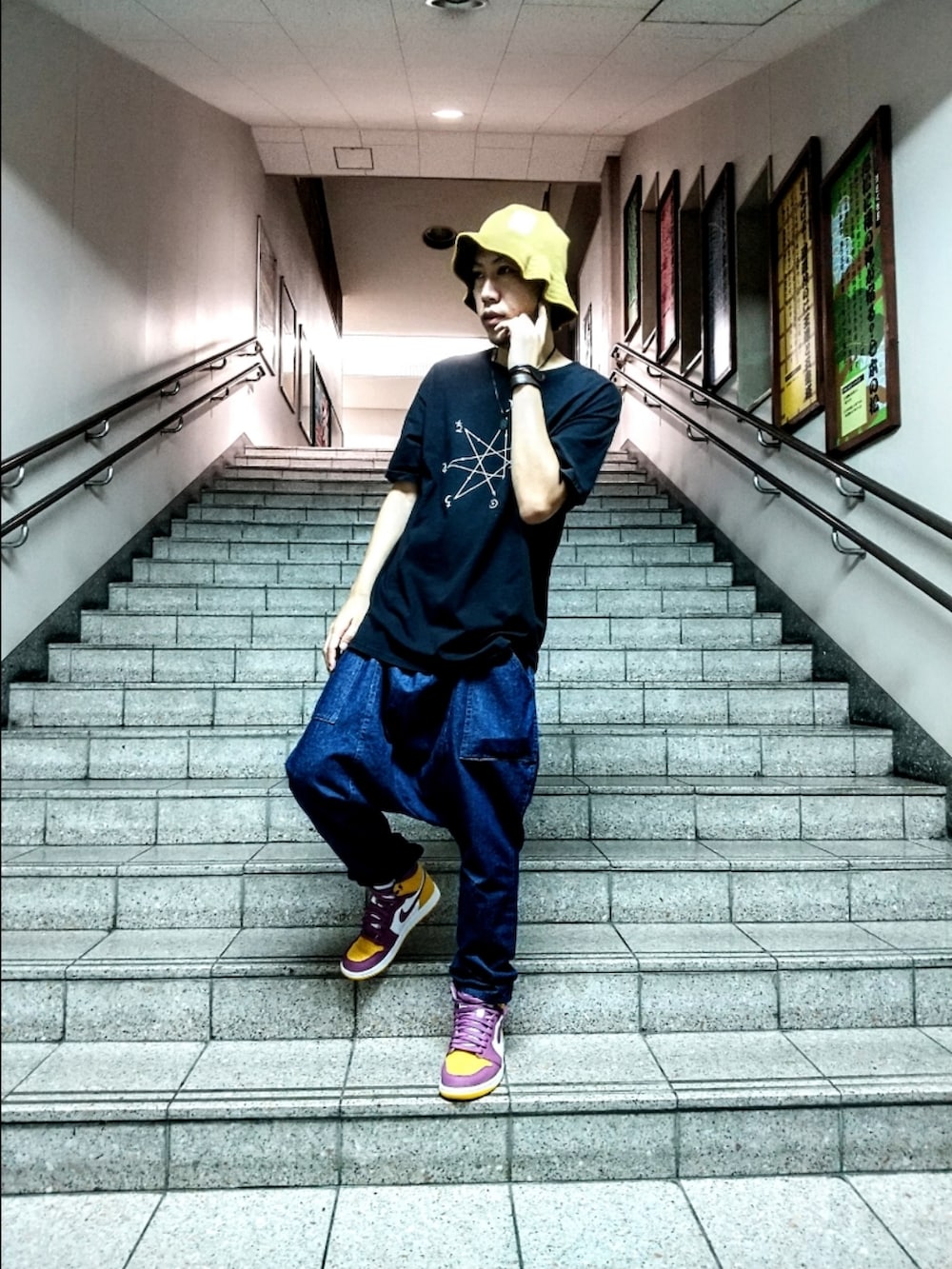 レッド系のTシャツ/カットソー、ブルー系のデニムパンツ、ホワイト系のスニーカーを着用したメンズの秋コーディネートの3枚目の写真