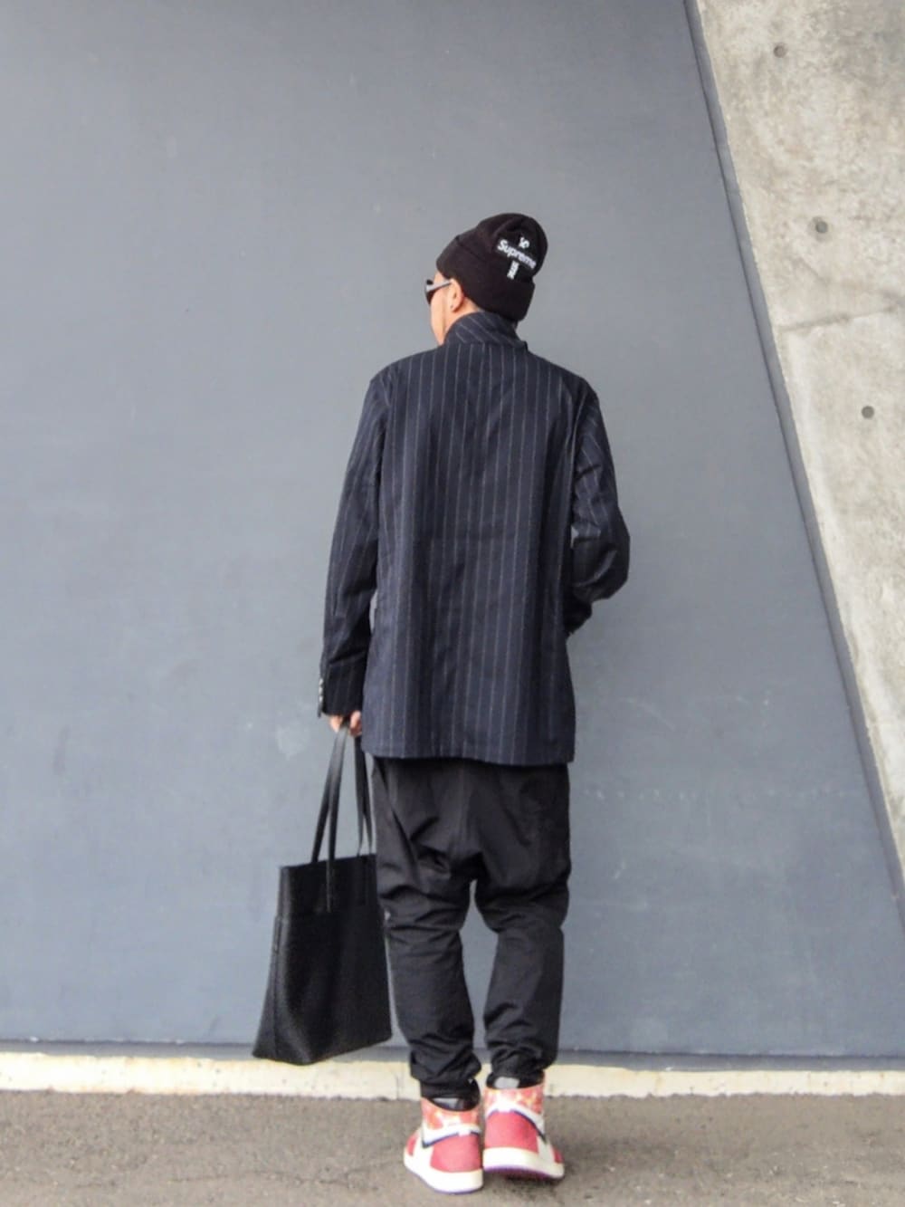 ブルー系のカバーオール、ブラック系のその他パンツ、レッド系のスニーカーを着用したメンズの秋コーディネートの2枚目の写真