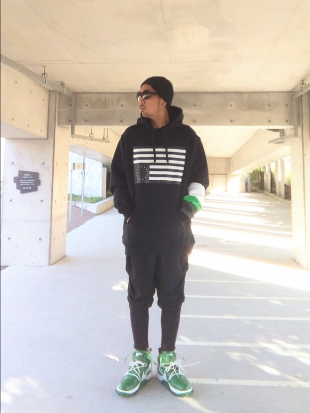 ブラック系のパーカー、ブラック系のその他パンツ、グリーン系のスニーカーを着用したメンズの秋コーディネートの2枚目の写真